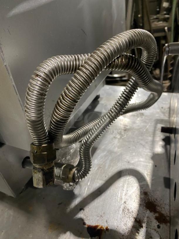 Cecilware stainless steel natural gas-powered deep fryer backside view, shows flexible gas connection hose.