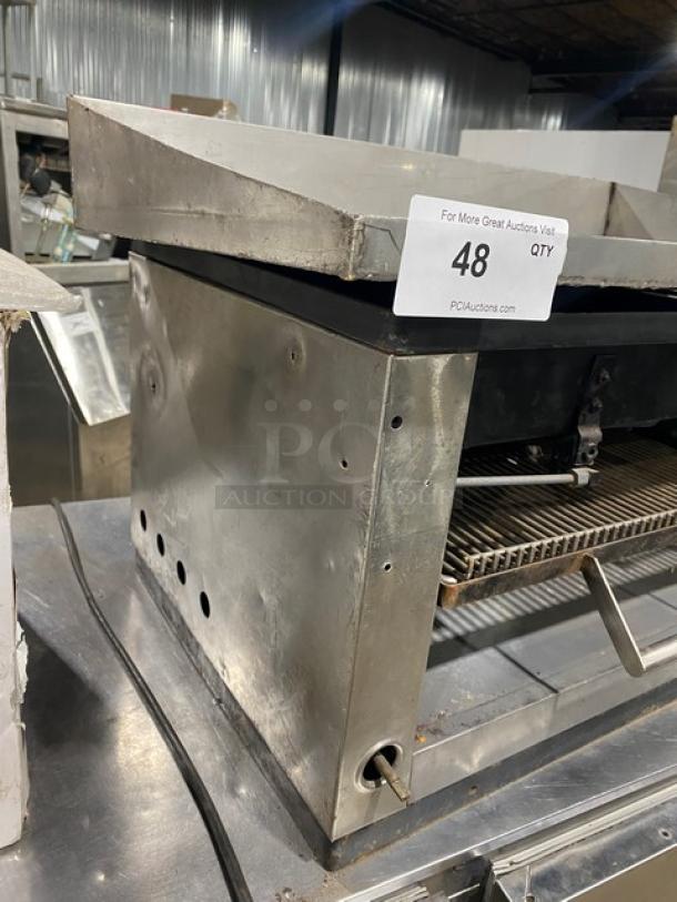 Commercial stainless steel gas-powered flat-griddle with broiler and cheese melter. Features raised countertop, back and side splash.