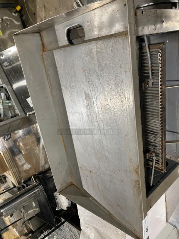 Commercial stainless steel gas griddle, raised countertop design, with back and side splash, and built-in broiler. Used condition.