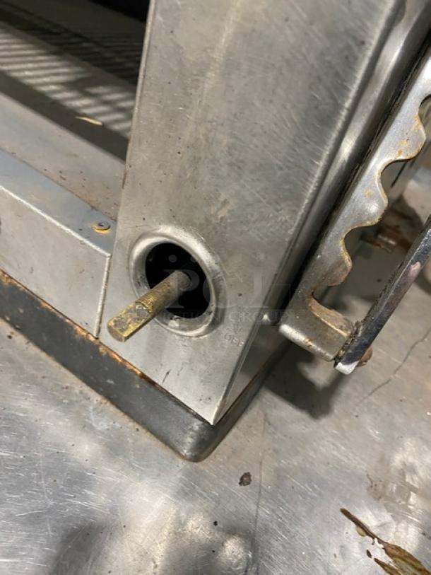 Commercial stainless steel gas flat griddle with back and side splash, and built-in broiler/cheese melter. Good condition.