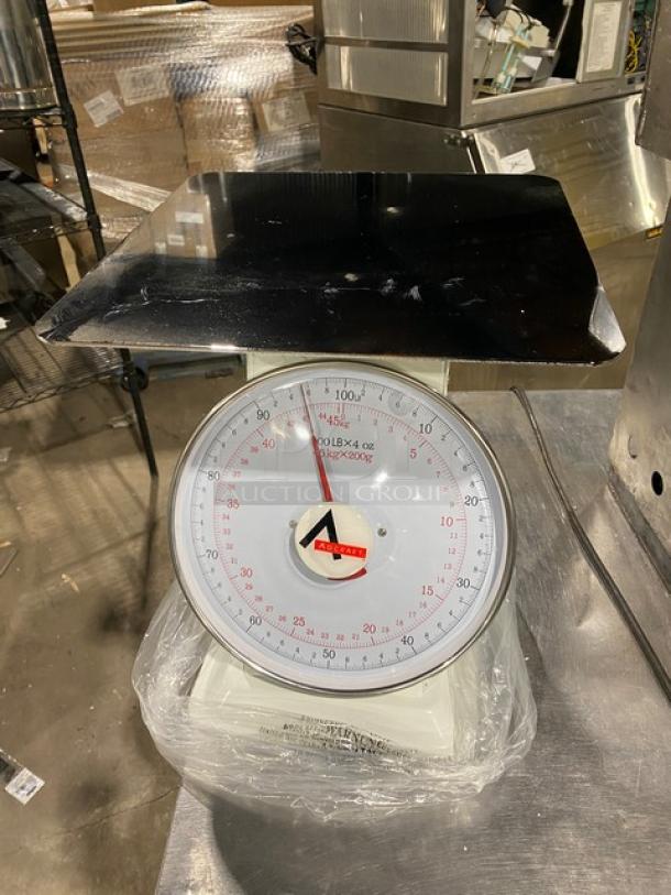 Adcraft commercial scale SCA100, new condition, 100 lb. capacity, 13.5" stainless steel platform, visible dial.