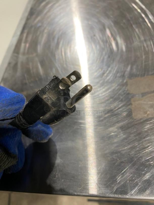 Power plug of Icetro IU0220AH ice machine being held, indicating electric-powered functionality.