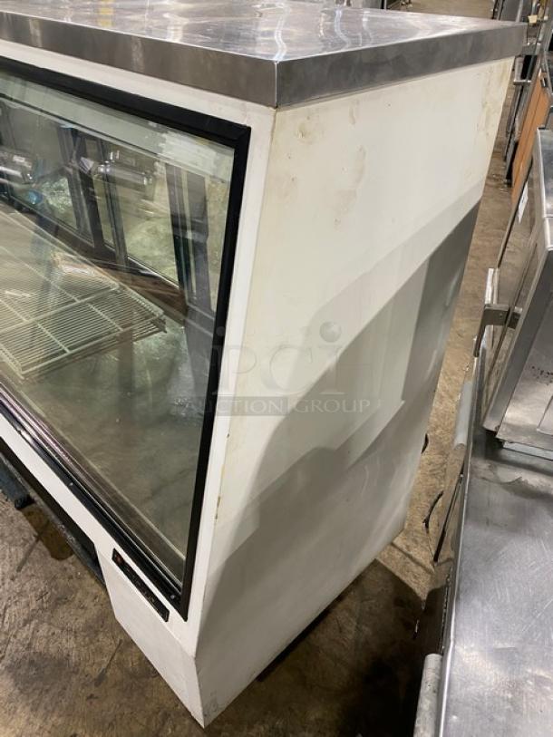 True Commercial TSID-96-3 refrigerated deli merchandiser, 96" wide, with slanted glass, rear sliding doors, poly coated wired rack.