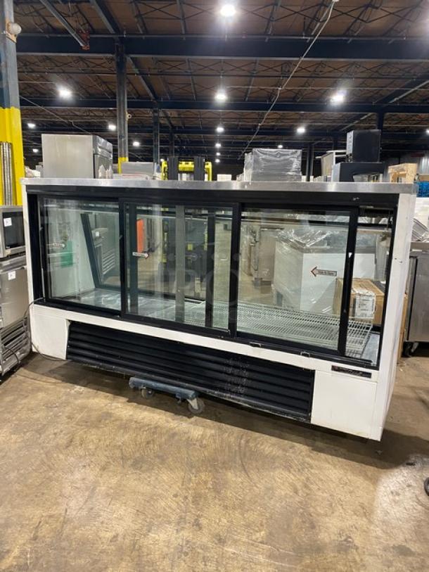 True Commercial 96" deli merchandiser display case with slanted glass, rear sliding doors, poly-coated rack. Model TSID-96-3.