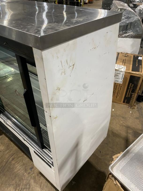 True commercial refrigerated deli display case, model TSID-96-3, 96", white with slanted glass, rear sliding doors, poly-coated wire rack.