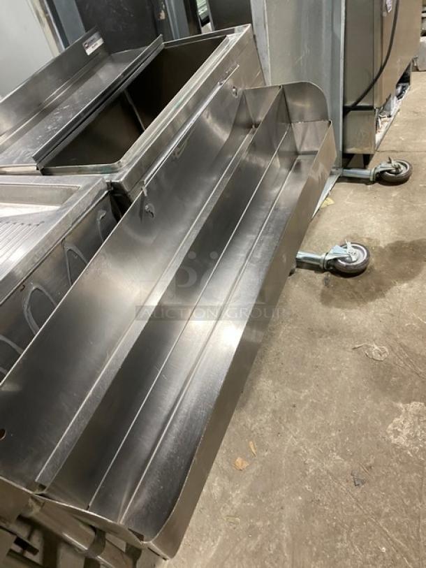 NBR Equipment stainless steel cocktail station with single compartment sink, drain board, ice bin, and double speed rail. Model IB-2418/UW-1-1012-1521-TDV, on legs.