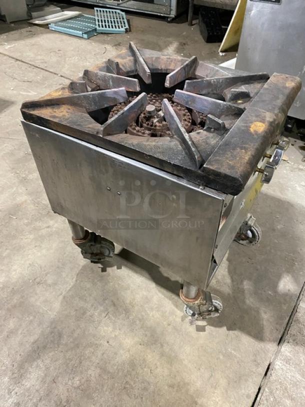 Commercial stainless steel gas-powered single burner stock pot range on casters, visible wear, functional condition.