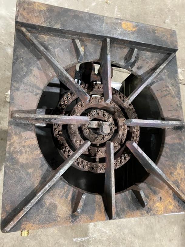 Commercial stainless steel gas-powered single burner stock pot range on casters, showing wear and rust.