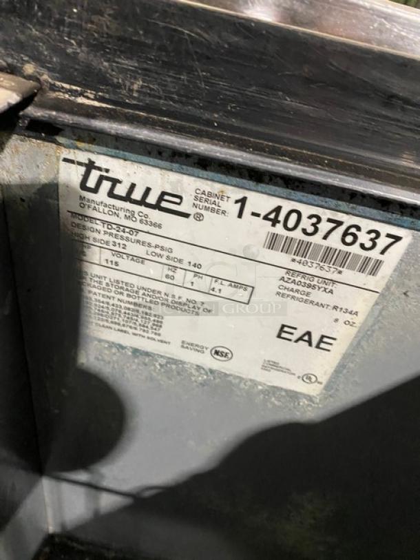 True commercial black bottle cooler, Model TD-24-07, with stainless steel sliding lid, serial 1-4037637, 115V, pre-owned condition.