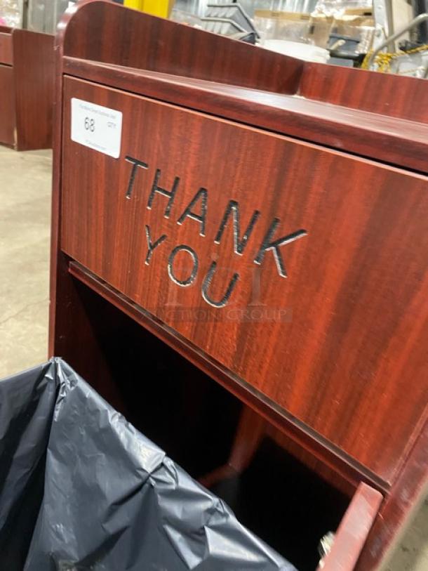 Commercial wooden waste cabinet with "Thank You" engraving, features a polished finish and black trash liner. Item tag visible.