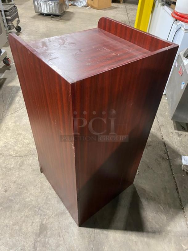 Commercial wooden enclosed trash receptacle cabinet with mahogany finish; minor surface wear; sturdy construction.