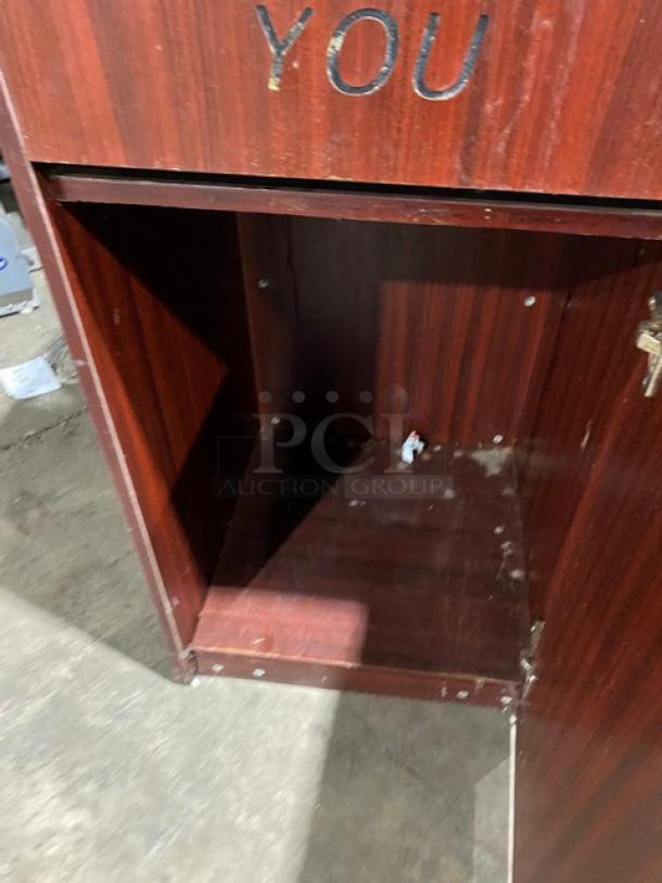Commercial wooden enclosed trash receptacle cabinet, "Thank You" style, with open door, showing moderate wear.