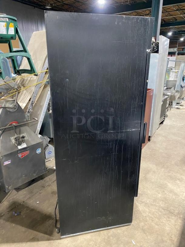 Beverage-Air MT27 commercial refrigerator, black finish, single glass swing door, poly-coated wire rack, scratches visible.