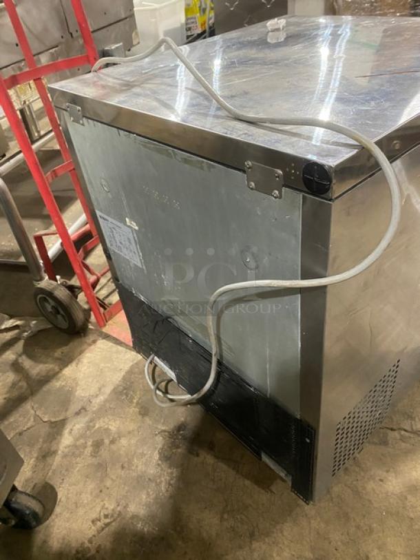 True TUF-28SD stainless steel undercounter worktop freezer with poly-coated rack, single door, 115V, on casters.