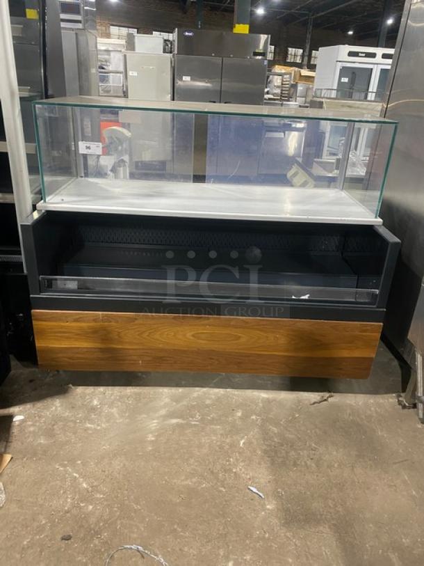 Structural Concepts SBZ6652DR black refrigerated open merchandiser with enclosed glass showcase, rear sliding doors, on legs.