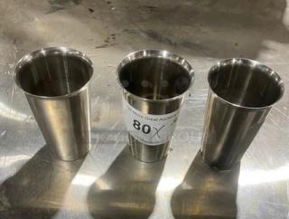 Three stainless steel malt shaker cups on a metal surface. One cup has an auction tag labeled "80X."