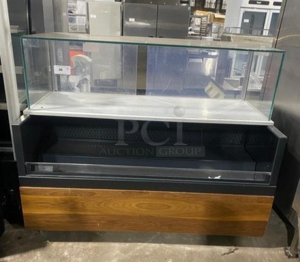 Structural Concepts SBZ6652DR black refrigerated open merchandiser with enclosed glass showcase, rear sliding doors, on legs.