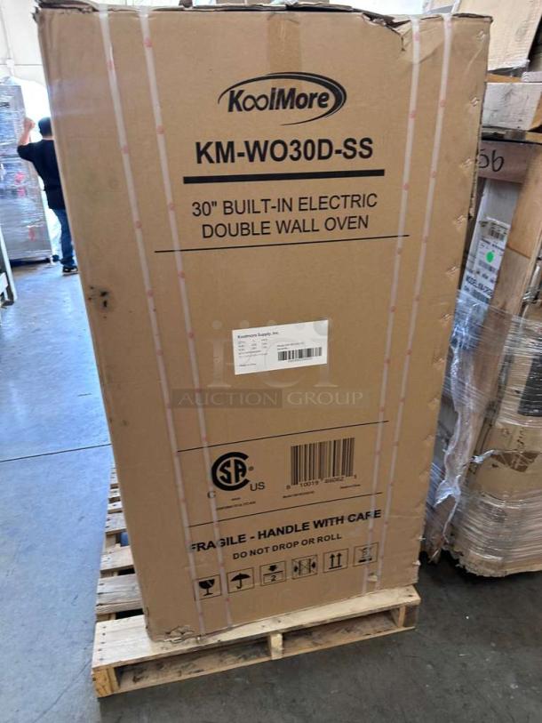 Brand new KoolMore KM-WO30D-SS 30" double wall oven in original packaging with handling instructions label visible.