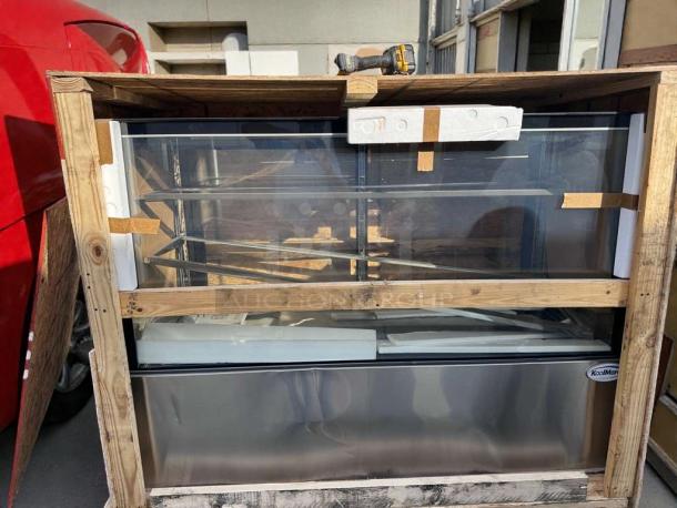 Brand new KoolMore Refrigerated Bakery Display Case, model KML-L-BDC-0031, in crate. Some scratches and dents visible.
