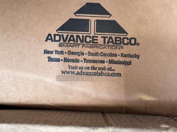 Advance Tabco work table packaging showing "Smart Fabrication" logo, locations, and website. Model KLAG-304-X, scratch & dent condition.
