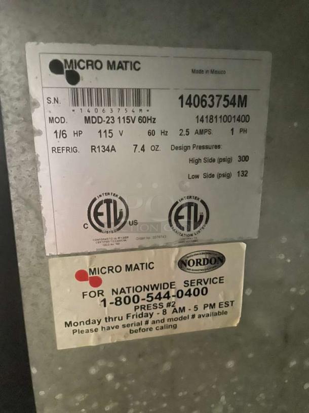 Micro Matic MDD-23 draft beer dispenser label showing model, voltage, refrigerant, and service contact details.
