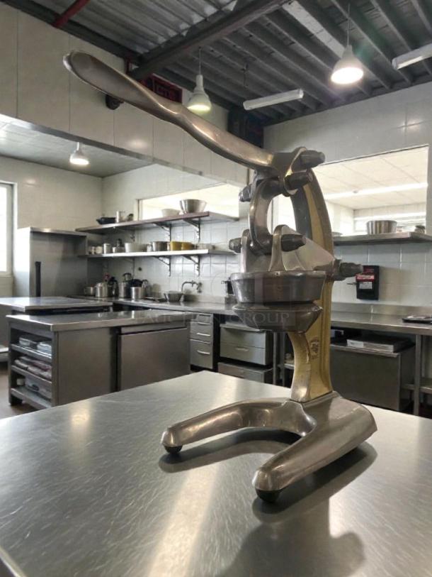 Excellent condition heavy-duty commercial manual citrus press, fully tested, silver finish, sturdy build.