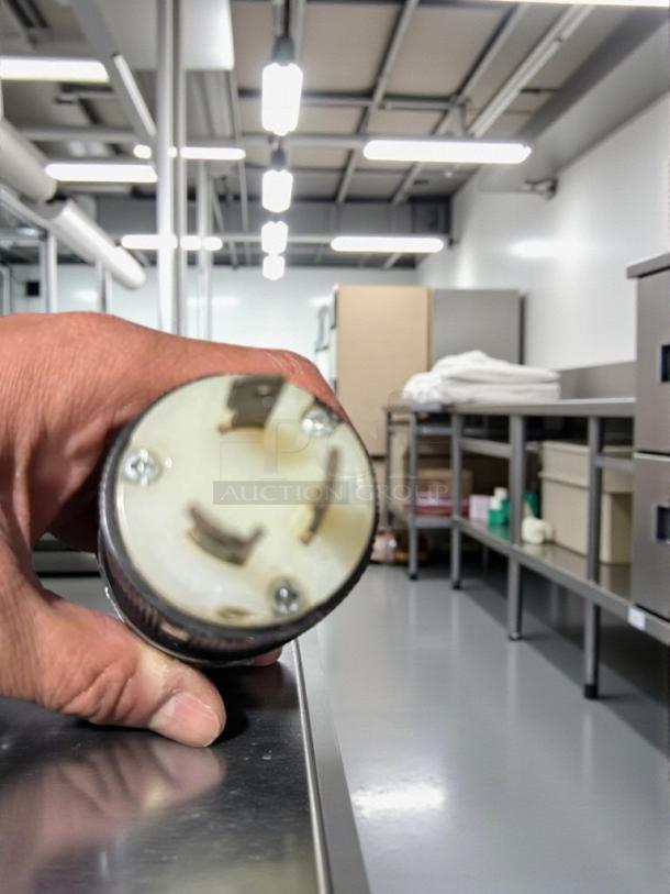Close-up of a 208V electric plug for the Moffat Turbofan E32MS oven in a professional kitchen setting.