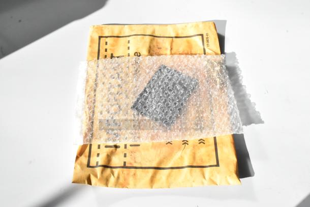Bubble-wrapped item on a yellow padded envelope. No visible markings on item or envelope.