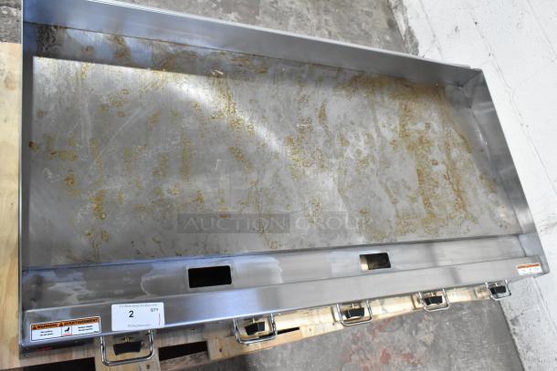 Brand new Wolf AGM60-101 gas griddle, 60" stainless steel, scratch and dent, manual controls, 135,000 BTU, tags visible.