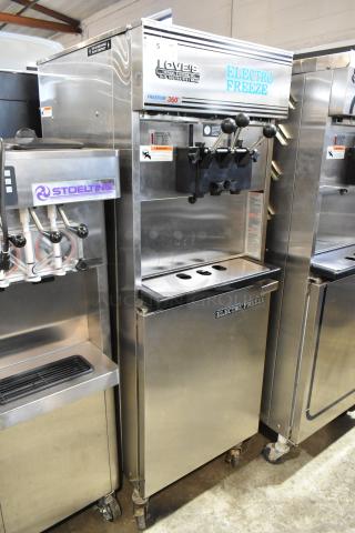Electro Freeze 99T-RMT-137 stainless steel soft serve ice cream machine, 2 flavors with twist, on commercial casters.