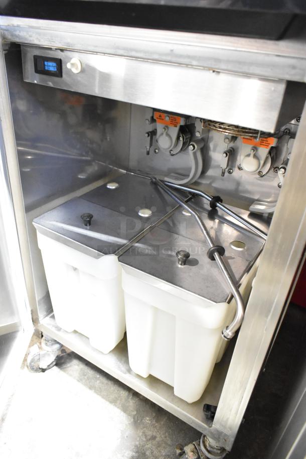 Electro Freeze 99T-RMT-137 stainless steel soft serve machine interior, showing dual containers and tubing on casters.