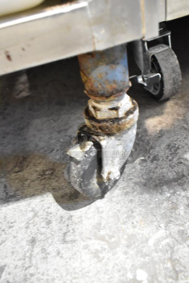 Rusty caster wheel of Electro Freeze 30T-CMT-132 soft serve machine. Shows wear, highlighting need for repair or replacement.