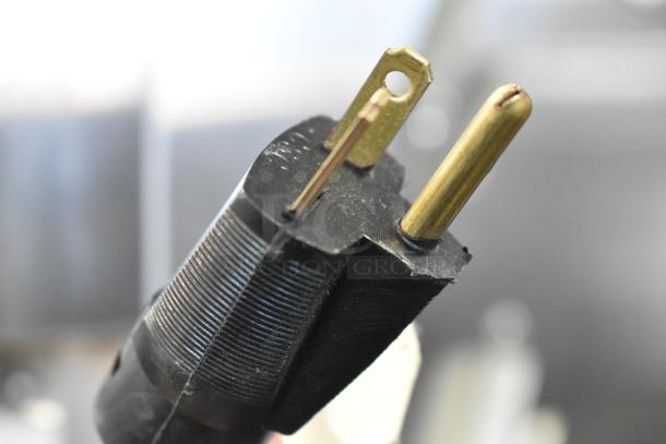 Close-up of a power plug for the Stoelting F231-18I2YGAD1 soft serve ice cream machine, showing prongs and detail.