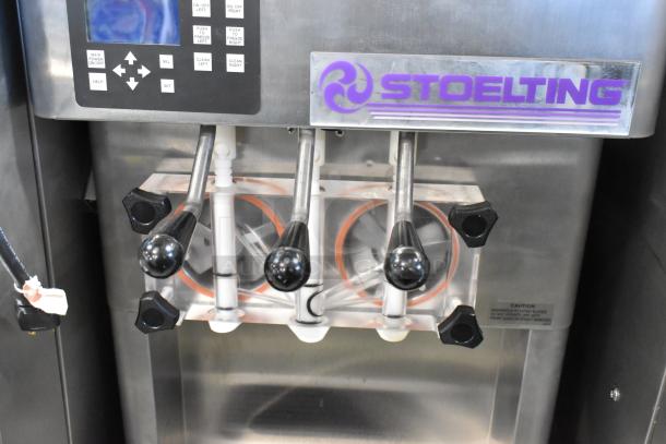 Stoelting F231-18I2YGAD1 stainless steel soft serve ice cream machine, dual flavor with twist, on casters, control panel visible.