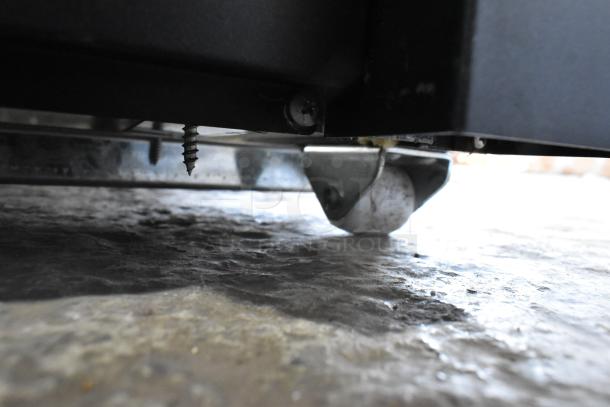 Close-up of Avantco 189BVAC46HC refrigerated merchandiser caster, highlighting the commercial wheel and lower frame.
