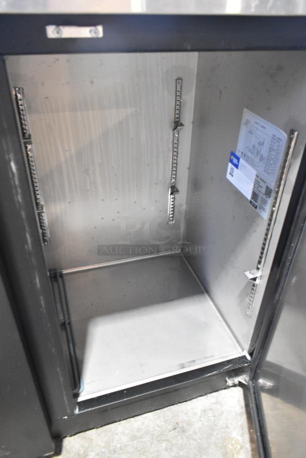 Avantco 178UBB72HC black back bar refrigerator, solid door open, stainless interior, LED lighting, label visible.