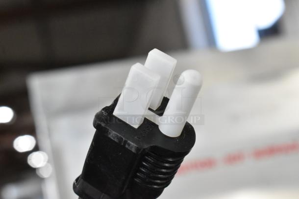 Close-up of the power plug for the Avantco 177HEAT1836I heated holding cabinet, black and white with visible prongs.