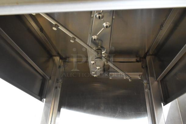 Champion stainless steel commercial corner pass-through dishwasher interior, showing spray arm assembly. Condition: good. 208-240V, 1 phase.