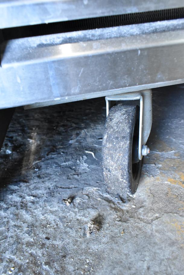 Traulsen TS066HT stainless steel commercial prep table, shown with a robust caster wheel for easy mobility.