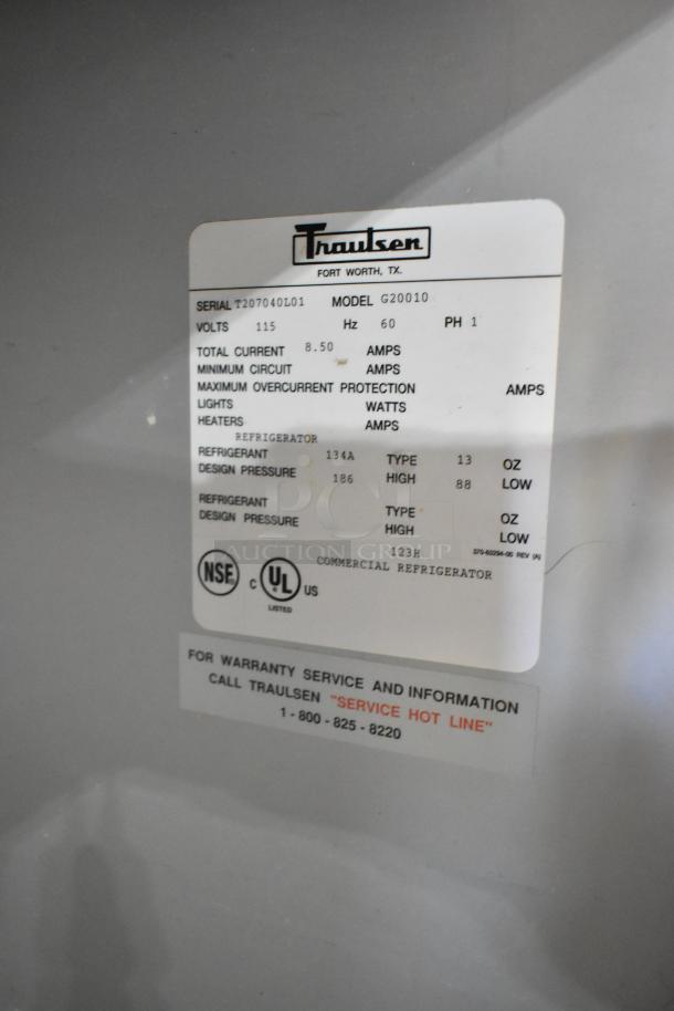 Traulsen G20010 stainless steel commercial cooler label, 115V, 1 phase, includes serial, refrigerant details, and service info.