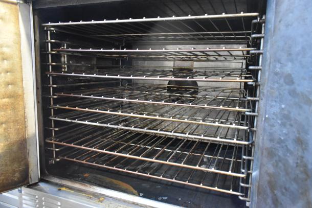 Two Garland Master 200 stainless steel convection ovens, solid doors, metal racks, thermostatic controls, on commercial casters.