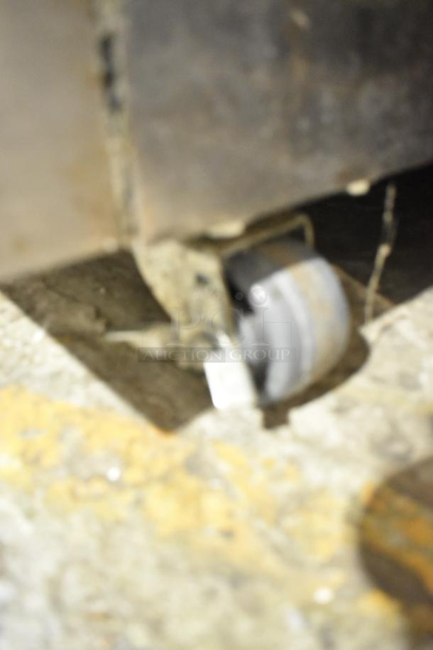 Blurry close-up of a caster wheel from a Garland Master 200 stainless steel convection oven, showing wear.