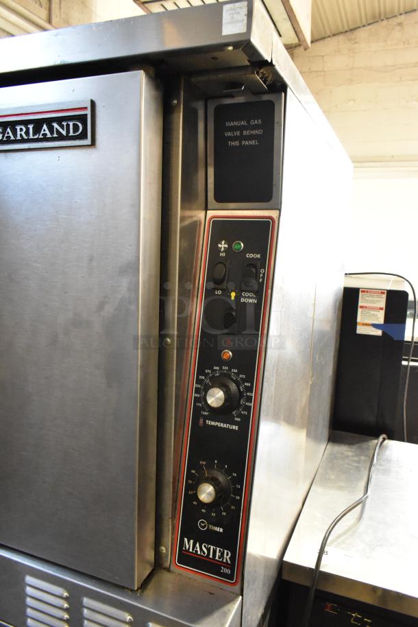 Garland Master 200 stainless steel convection oven with solid doors, metal racks, and thermostatic controls on casters.