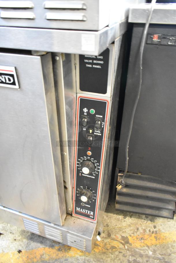 2 Garland Master 200 stainless steel convection ovens with solid doors, metal racks, thermostatic controls, on casters.
