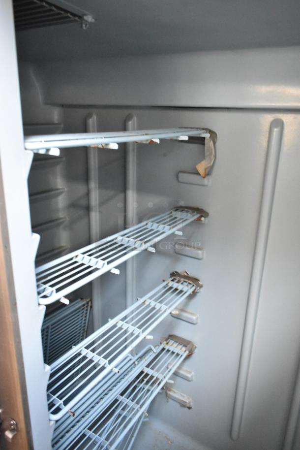 Delfield stainless steel commercial 2-door reach-in cooler, left door locked, 115 volts, 1 phase; interior shelving shown.