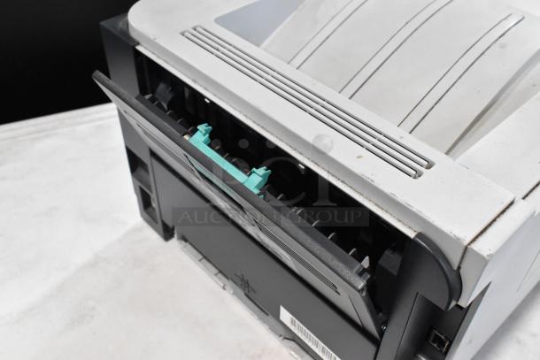 HP LaserJet P2055dn printer, used condition, visible paper tray and external connectors, minor surface wear.