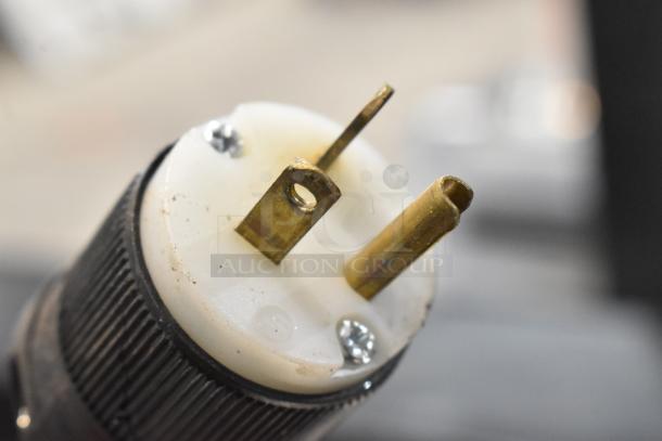 Close-up of an electrical plug, possibly from a Turbo Air TOM-60SB merchandiser. Features metal prongs and screw details.