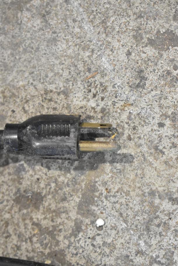 Close-up image of a black electrical plug on a textured surface, part of the Flavor Fantasia MR-7 drink mixer, 115V, 1 Phase.