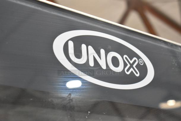 Cadco Unox XAVC-10FS-GPR combi oven, stainless steel, on equipment pan rack stand, visible Unox logo, commercial-grade.