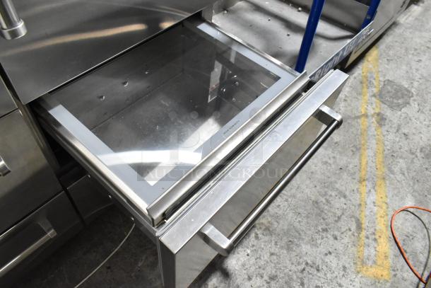 Sub Zero stainless steel commercial 2-door unit with 4 drawers; 115 volts, 1 phase. Visible open drawer showing sleek design.